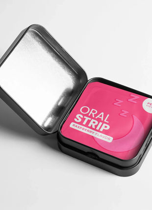 Pink oral strip in a black tin with a white lid on a light gray background
